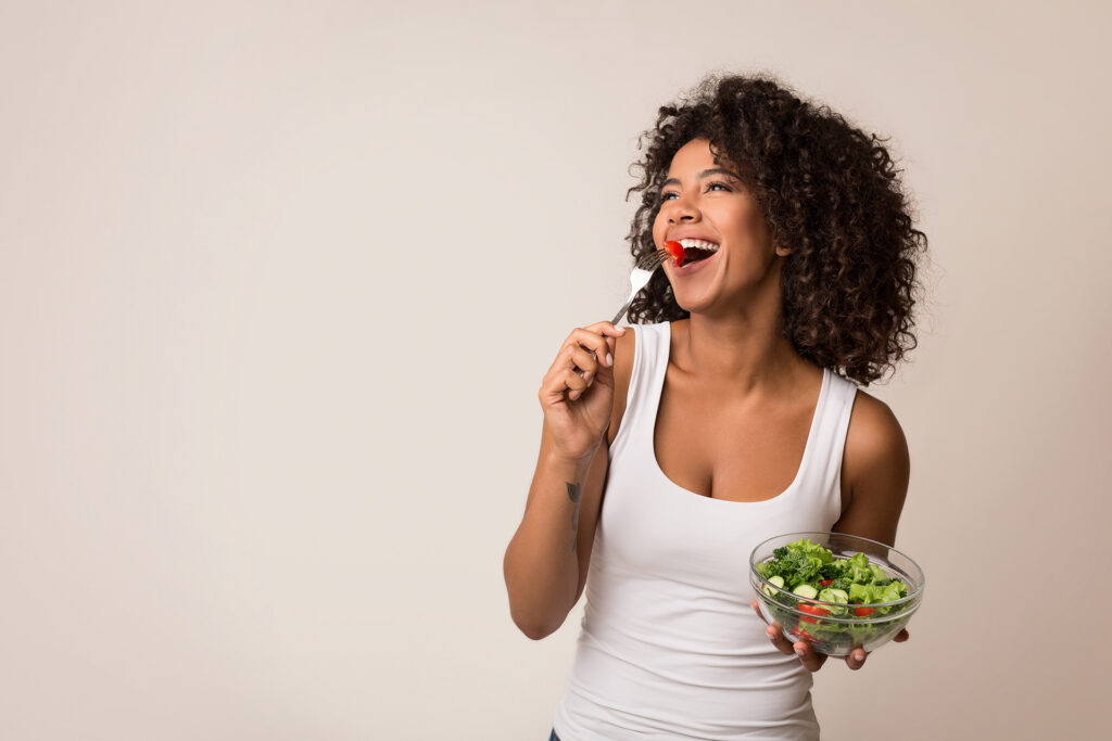 Woman eating a salad as she feels healthy after getting IV Nutrition.